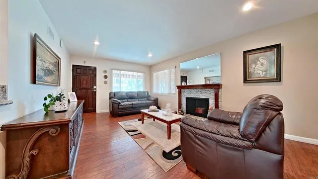 a living room with furniture mirror on the wall and a fireplace