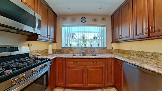 a kitchen with granite countertop cabinets sink and stainless steel appliances