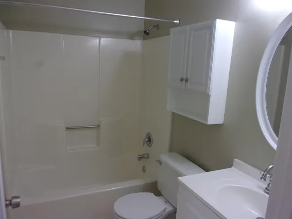 a bathroom with a sink vanity mirror and toilet