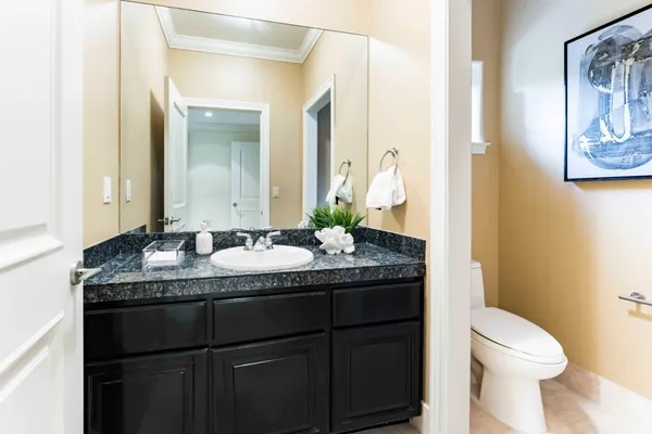 a bathroom with a granite countertop sink a toilet and a mirror