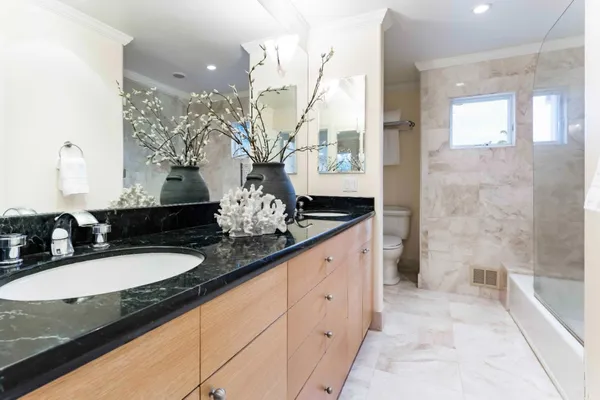 a bathroom with a granite countertop sink and a mirror