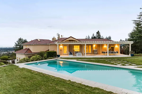 a view of a house with a big yard and a large pool