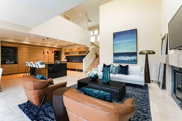 a living room with furniture a fireplace and a kitchen view