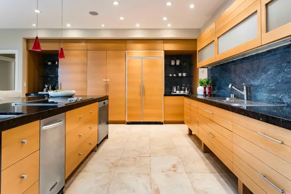 a large kitchen with stainless steel appliances granite countertop a sink and cabinets
