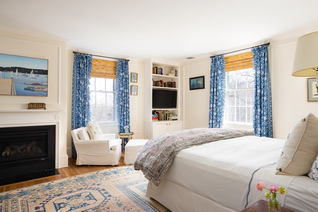 371 Walnut Street Brookline, MA 02445 - Photo 17 of 40 a bedroom with a large bed and a fireplace
