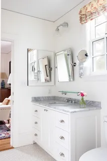 a bathroom with a granite countertop sink mirror vanity and toilet