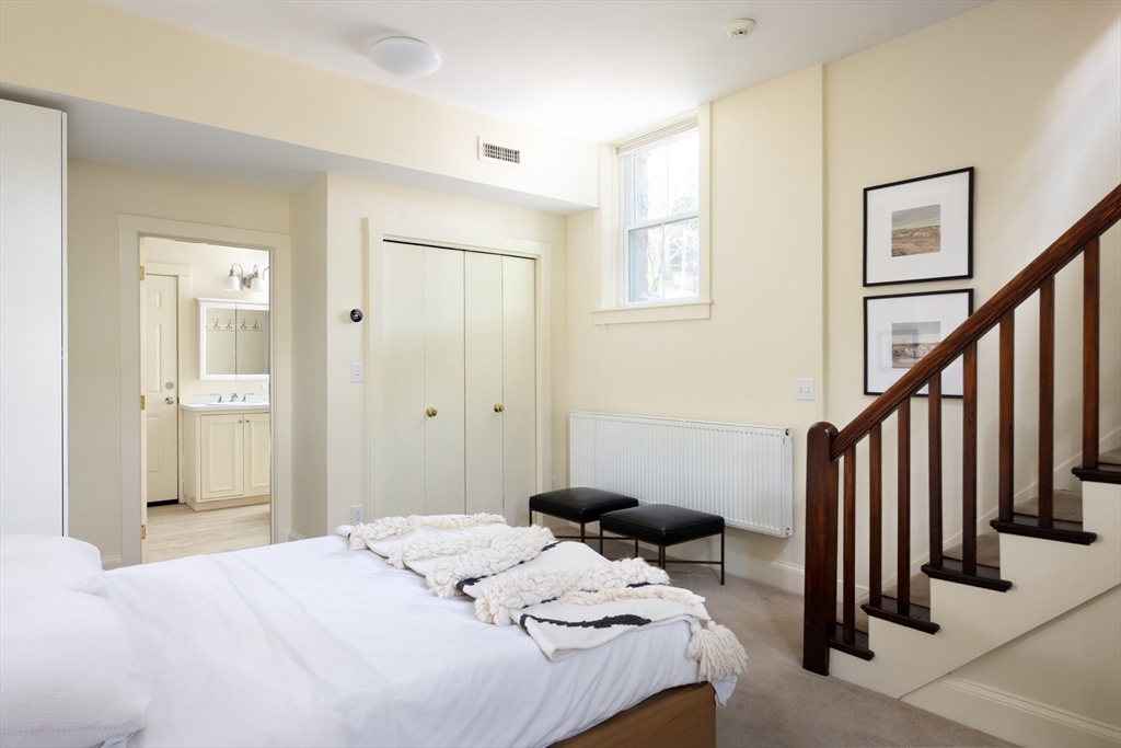 371 Walnut Street Brookline, MA 02445 - Photo 37 of 40 a bedroom with a bed and a chandelier