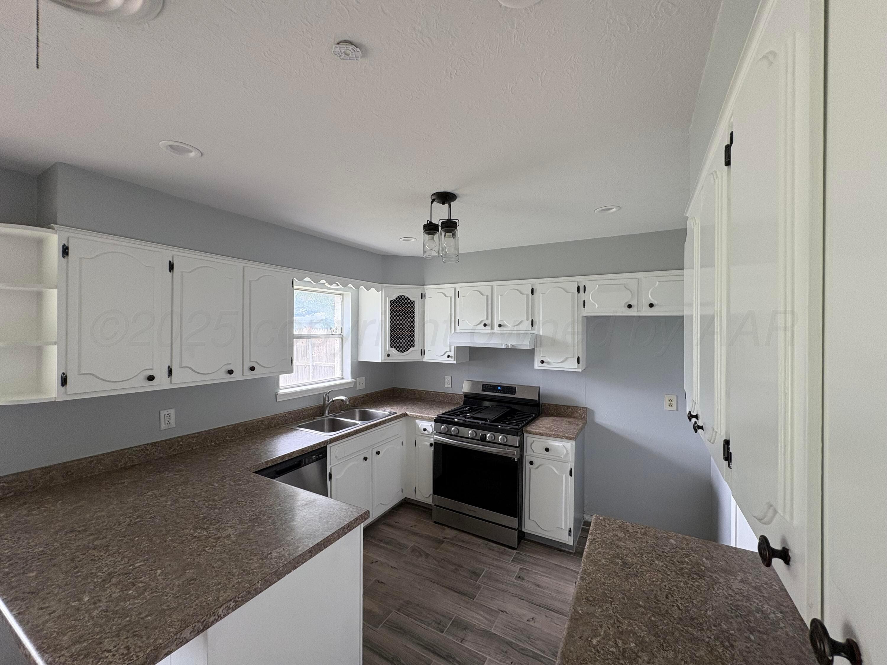 7205 Jameson Road Amarillo, TX 79106 - Photo 4 of 13 a kitchen with stainless steel appliances granite countertop a sink stove and refrigerator