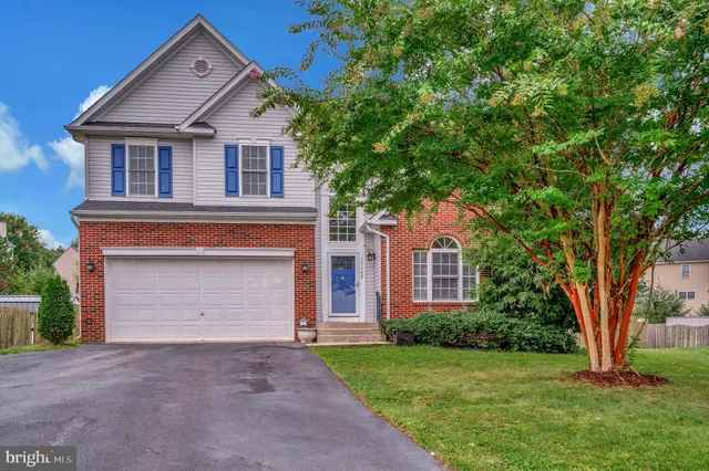 front view of a house with a yard and an trees