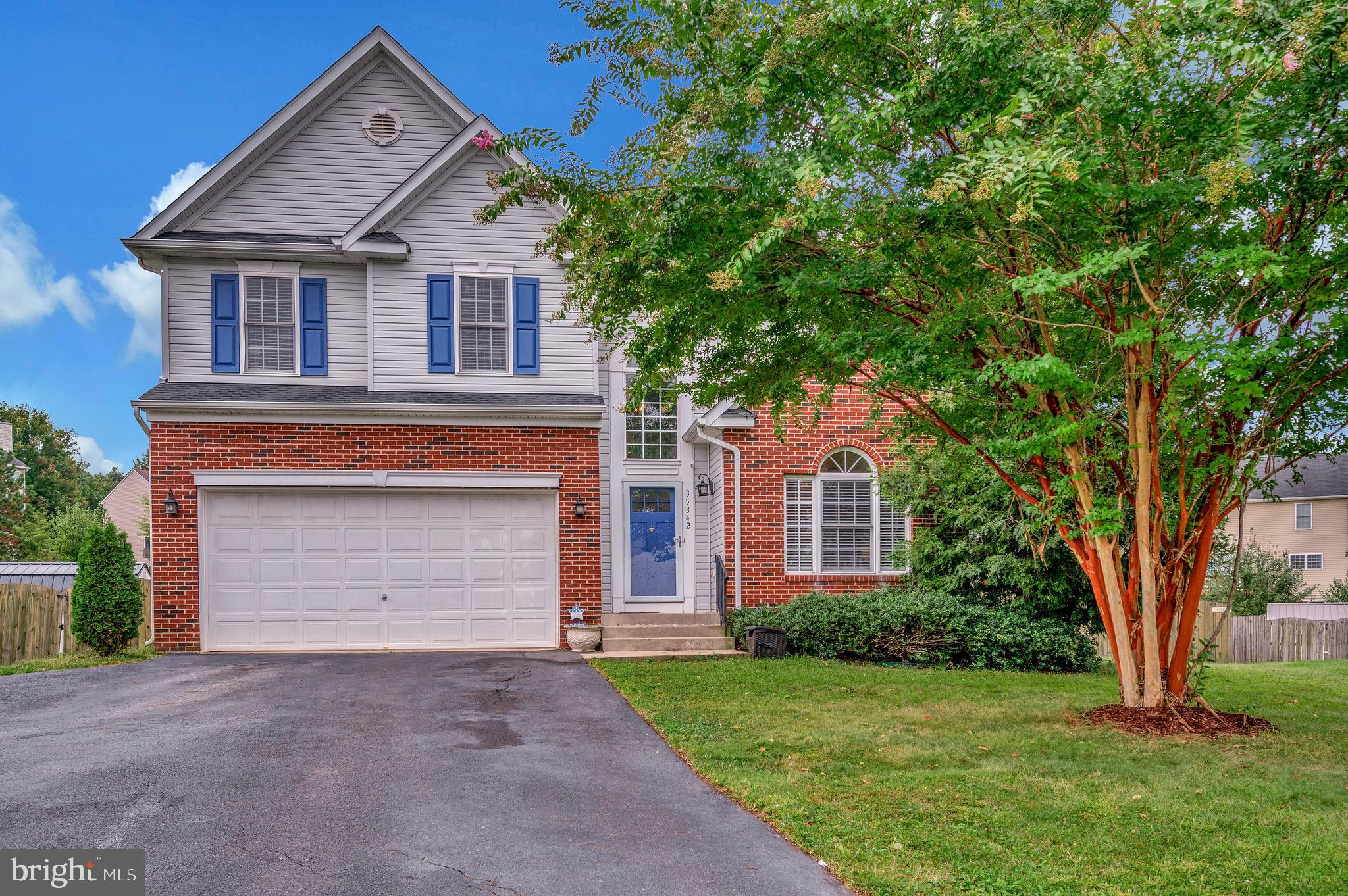 front view of a house with a yard and an trees