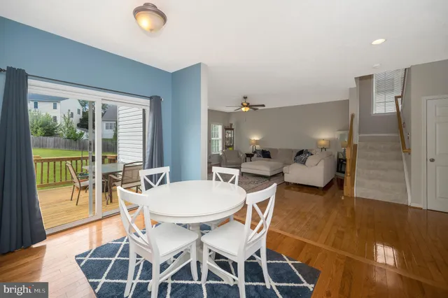 a kitchen with stainless steel appliances a stove a sink dishwasher a refrigerator white cabinets and wooden floor