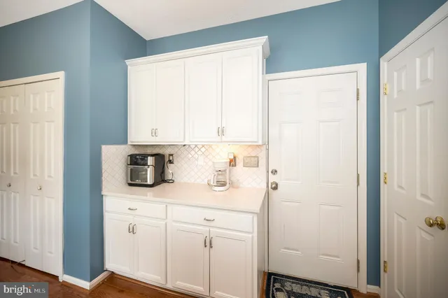 a kitchen with a sink a counter space appliances and cabinets