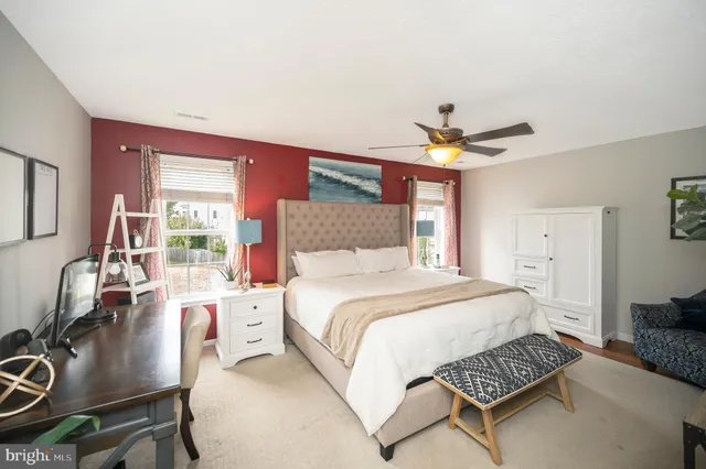 a spacious bedroom with a bed a chandelier and a flat screen television