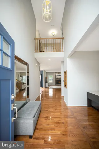 a view of a hallway with wooden floor and a livingroom with furniture