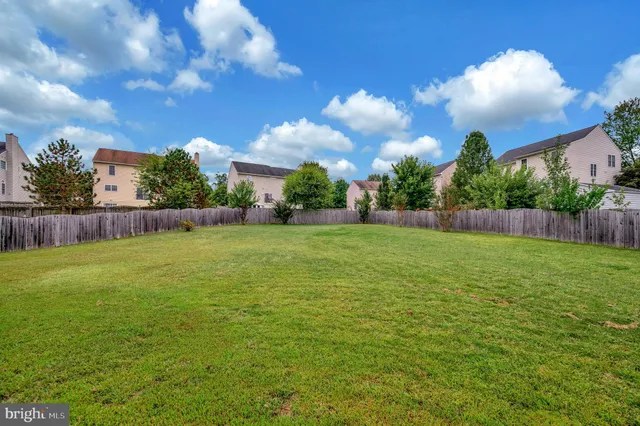 a view of a patio with table and chairs with wooden floor and fence