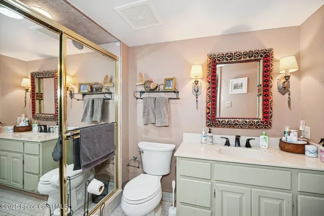 a bathroom with a granite countertop toilet sink and mirror