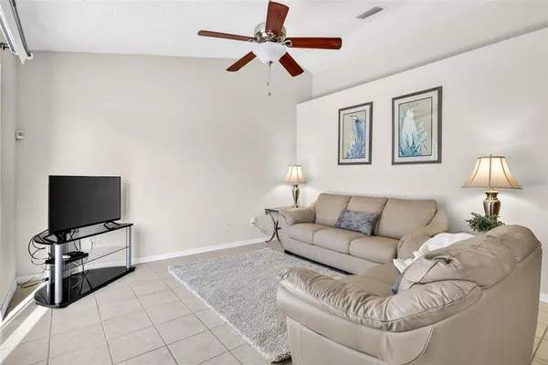 a living room with furniture a flat screen tv and a large window