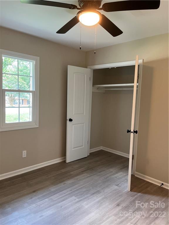 220 Pine Road Mount Holly, NC 28120 - Photo 12 of 20 an empty room with wooden floor fan and windows