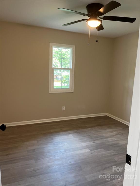 220 Pine Road Mount Holly, NC 28120 - Photo 13 of 20 an empty room with wooden floor chandelier fan and windows