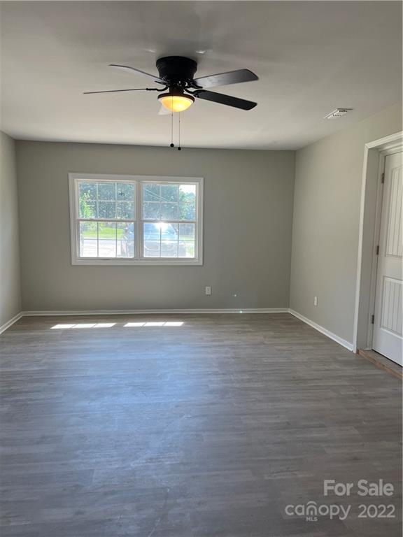 220 Pine Road Mount Holly, NC 28120 - Photo 9 of 20 an empty room with wooden floor and windows