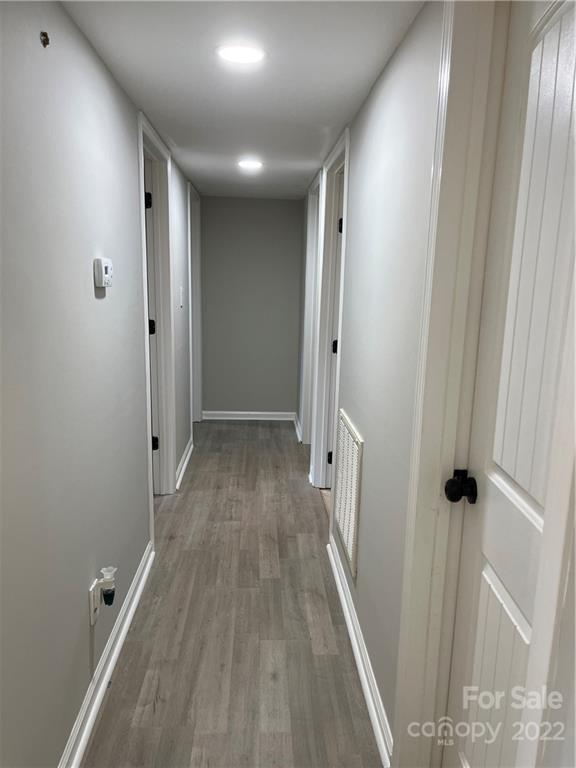 220 Pine Road Mount Holly, NC 28120 - Photo 10 of 20 a view of a hallway with wooden floor and a bathroom