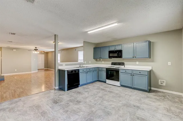 a large kitchen with a stove top oven and cabinets