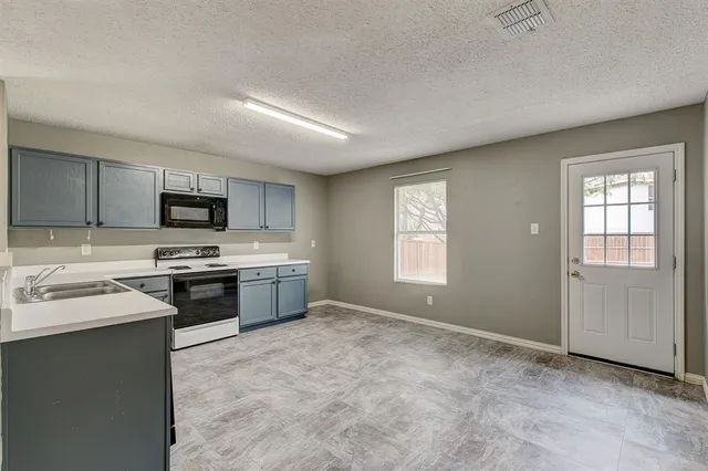 a kitchen with stainless steel appliances a stove sink and microwave