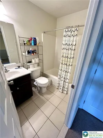 a bathroom with a sink a toilet and shower curtain