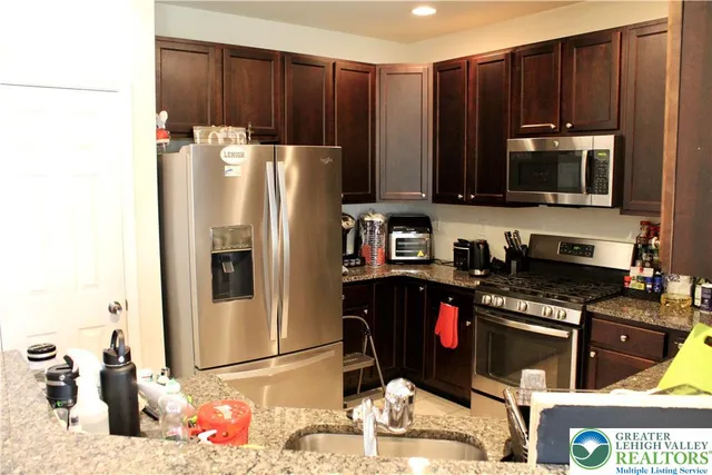 a kitchen with stainless steel appliances wooden cabinets and a refrigerator