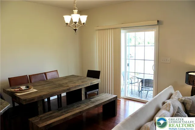 a view of a dining room with furniture a chandelier and a window