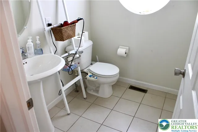 a white toilet sitting next to a white sink and vanity