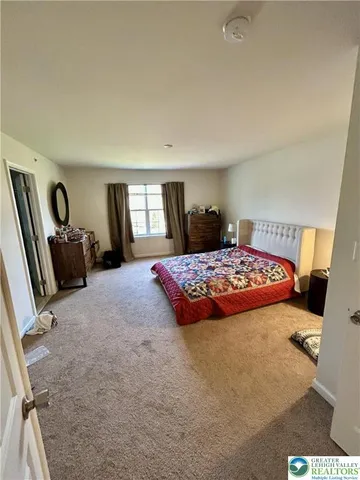 a bedroom with a large bed and a dresser in it