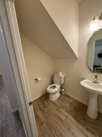 a bathroom with a toilet a sink and mirror