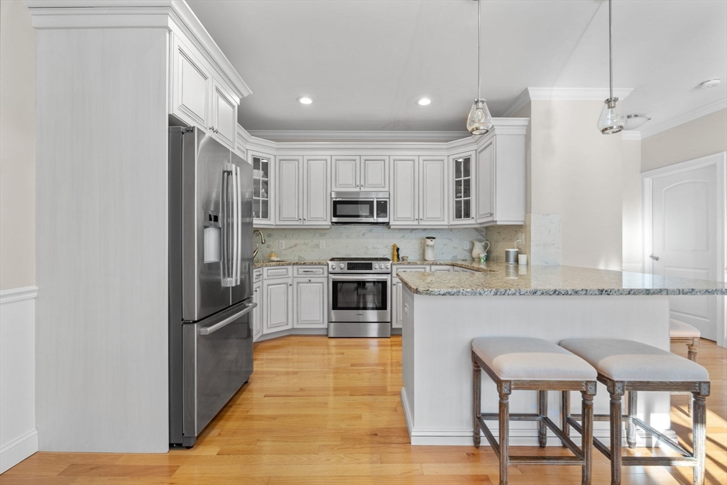 11 Cranberry Lane, Unit 11 Middleton, MA 01949 - Photo 5 of 29 a kitchen with stainless steel appliances granite countertop a stove a sink refrigerator and a microwave