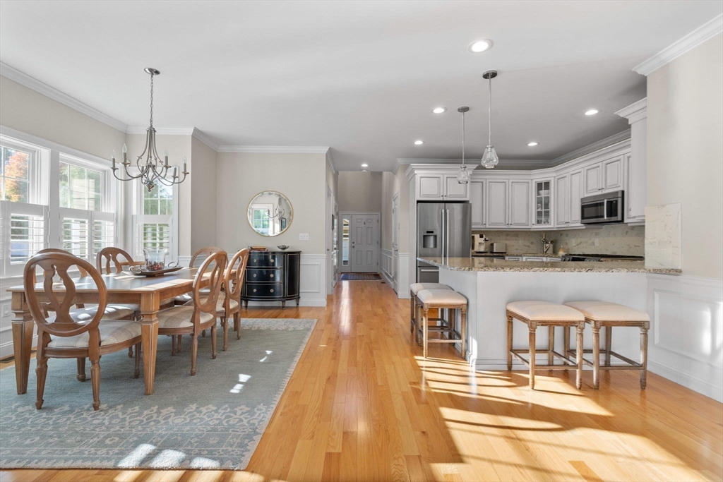 11 Cranberry Lane, Unit 11 Middleton, MA 01949 - Photo 6 of 29 a view of a dining room and livingroom with furniture wooden floor a chandelier