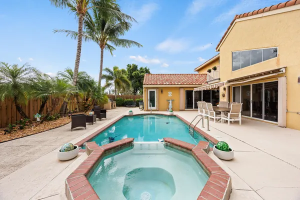 a view of a house with swimming pool and sitting area