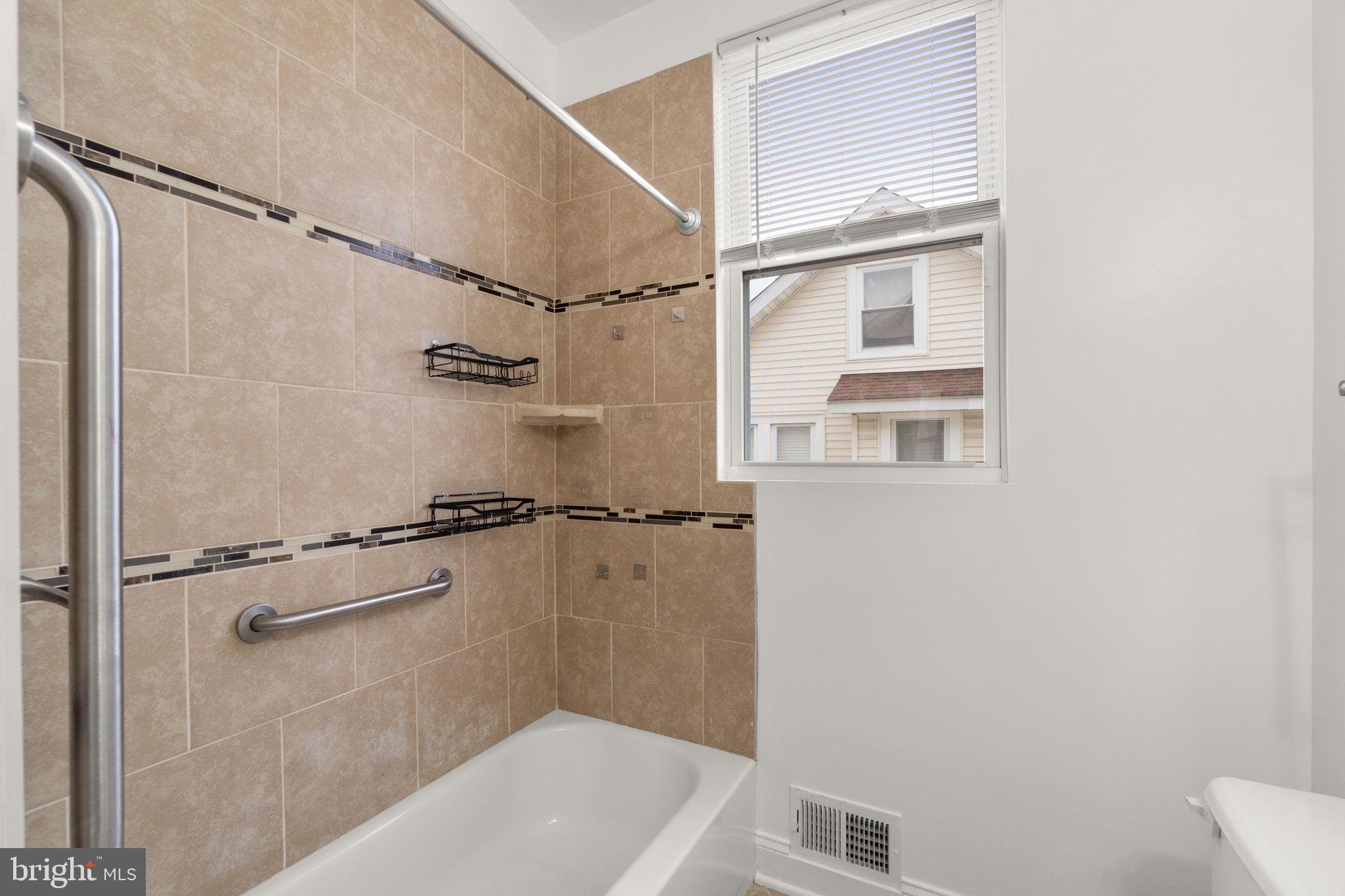 4525 Mainfield Avenue Baltimore, MD 21214 - Photo 12 of 33 a bathroom with a bathtub and a shower