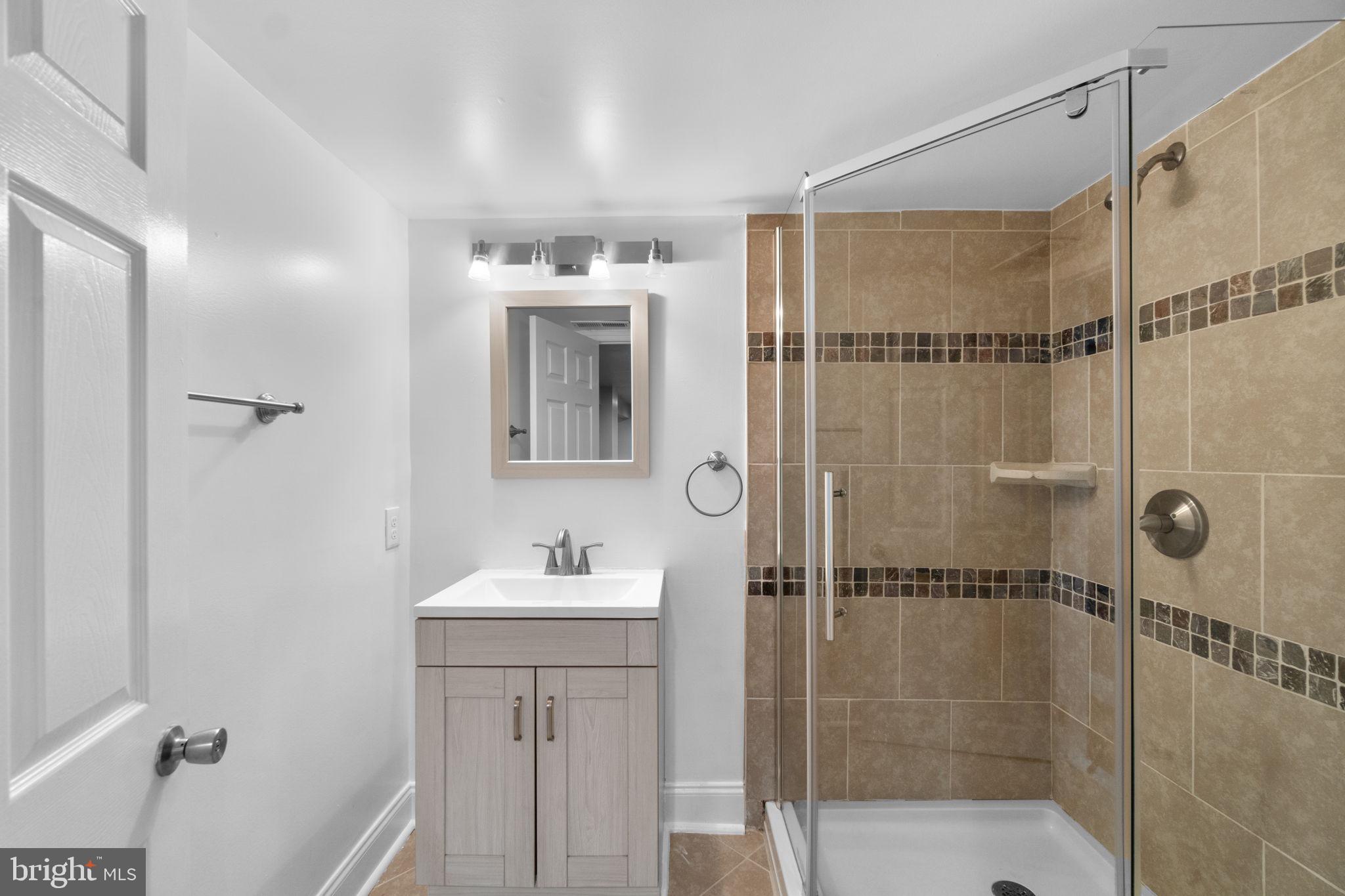 4525 Mainfield Avenue Baltimore, MD 21214 - Photo 21 of 33 a bathroom with a shower sink and mirror