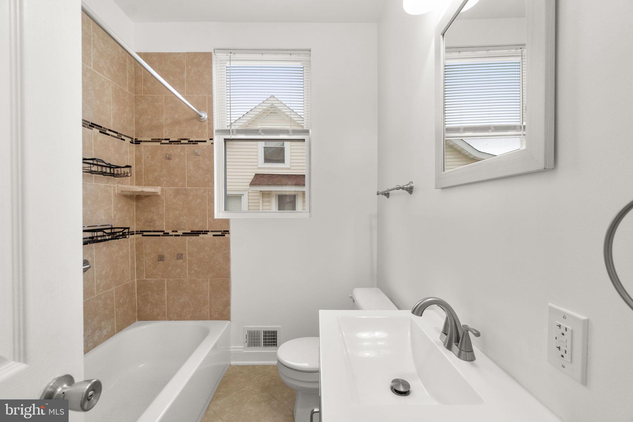 4525 Mainfield Avenue Baltimore, MD 21214 - Photo 4 of 33 a bathroom with a sink a toilet and a bathtub