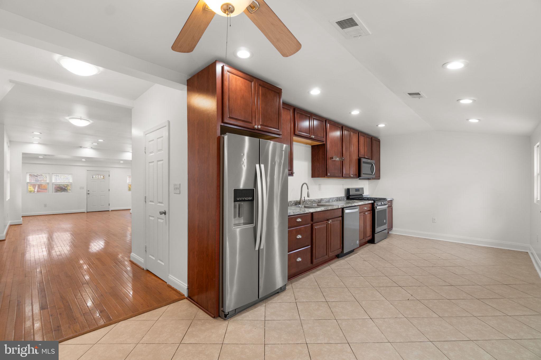 4525 Mainfield Avenue Baltimore, MD 21214 - Photo 8 of 33 a open kitchen with stainless steel appliances kitchen island granite countertop a refrigerator and a sink