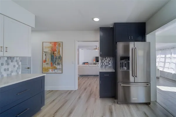 a kitchen with stainless steel appliances a refrigerator and wooden floor