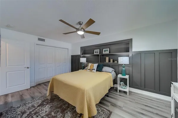 a bed sitting in a spacious bedroom next to a window and a chandelier