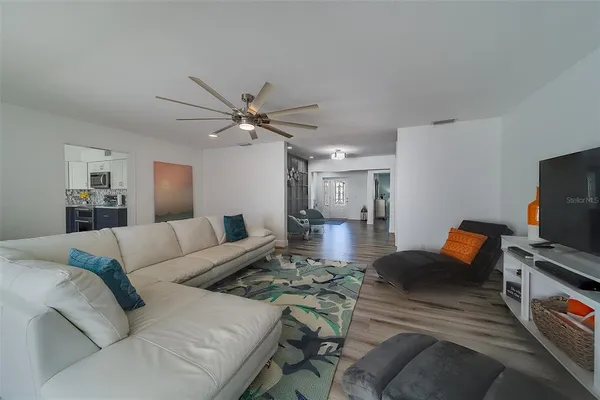 a living room with furniture a flat screen tv and a chandelier