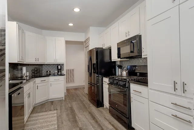a kitchen with granite countertop a refrigerator stove top oven and sink