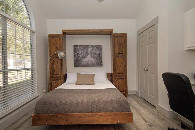 a bedroom with a large bed and a chair