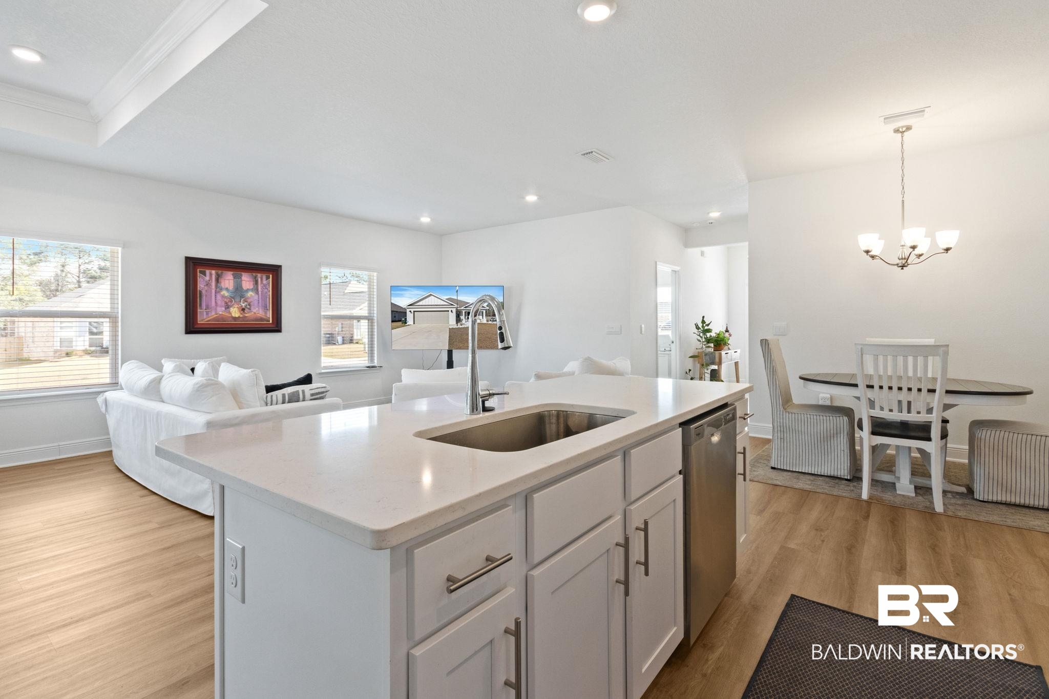 12919 Torrent Road Fairhope, AL 36532 - Photo 73 of 74 Kitchen featuring open floor plan, white cabinetry, a center island with sink, light wood finished floors, and light stone countertops