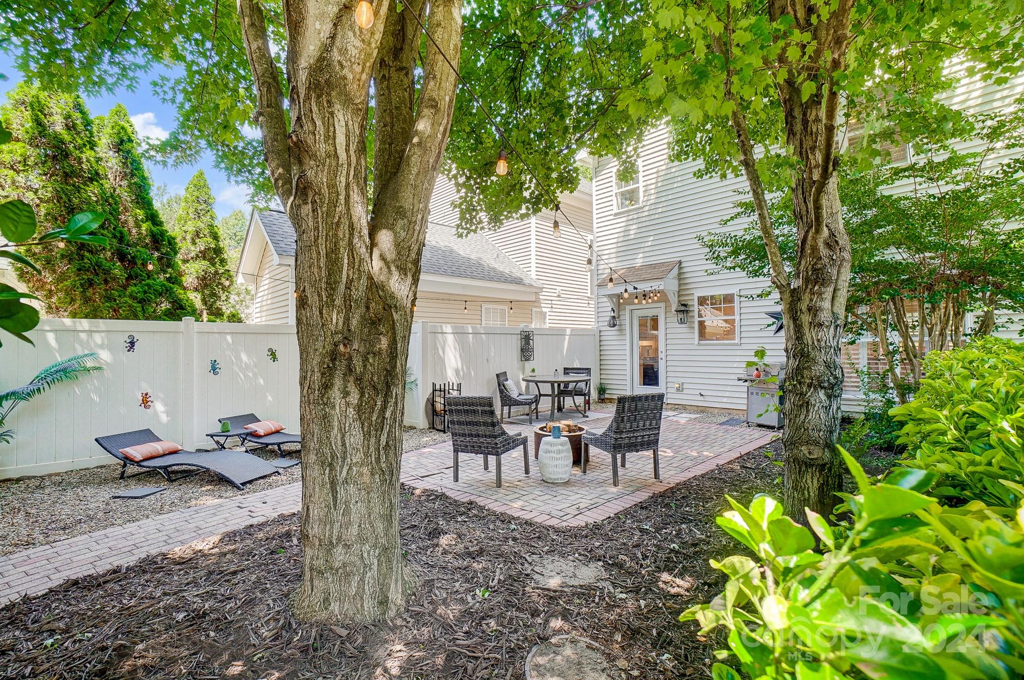 11343 Deer Ridge Lane Charlotte, NC 28277 - Photo 32 of 35 a view of a patio with table and chairs potted plants and large tree