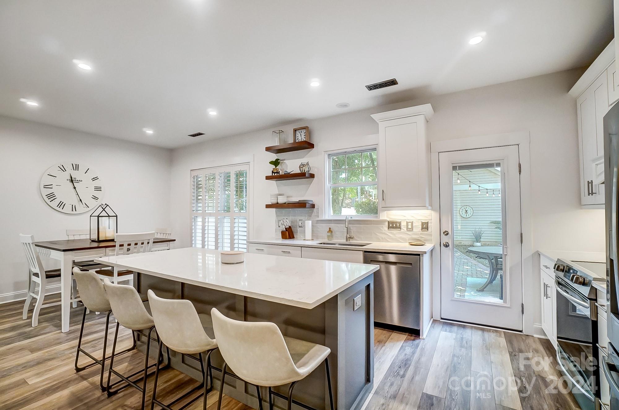 11343 Deer Ridge Lane Charlotte, NC 28277 - Photo 5 of 35 a kitchen with stainless steel appliances granite countertop a stove a sink dishwasher a dining table and chairs with wooden floor