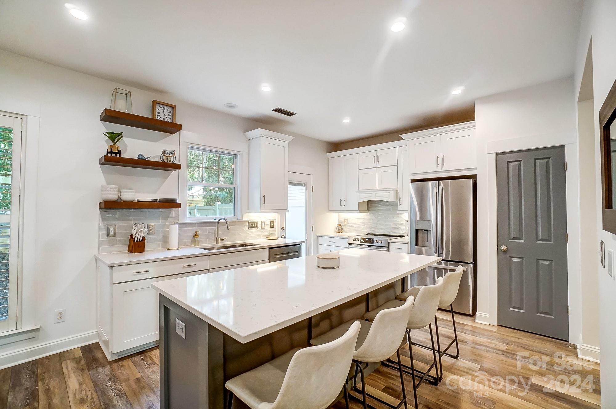 11343 Deer Ridge Lane Charlotte, NC 28277 - Photo 8 of 35 a kitchen with a table chairs refrigerator and cabinets