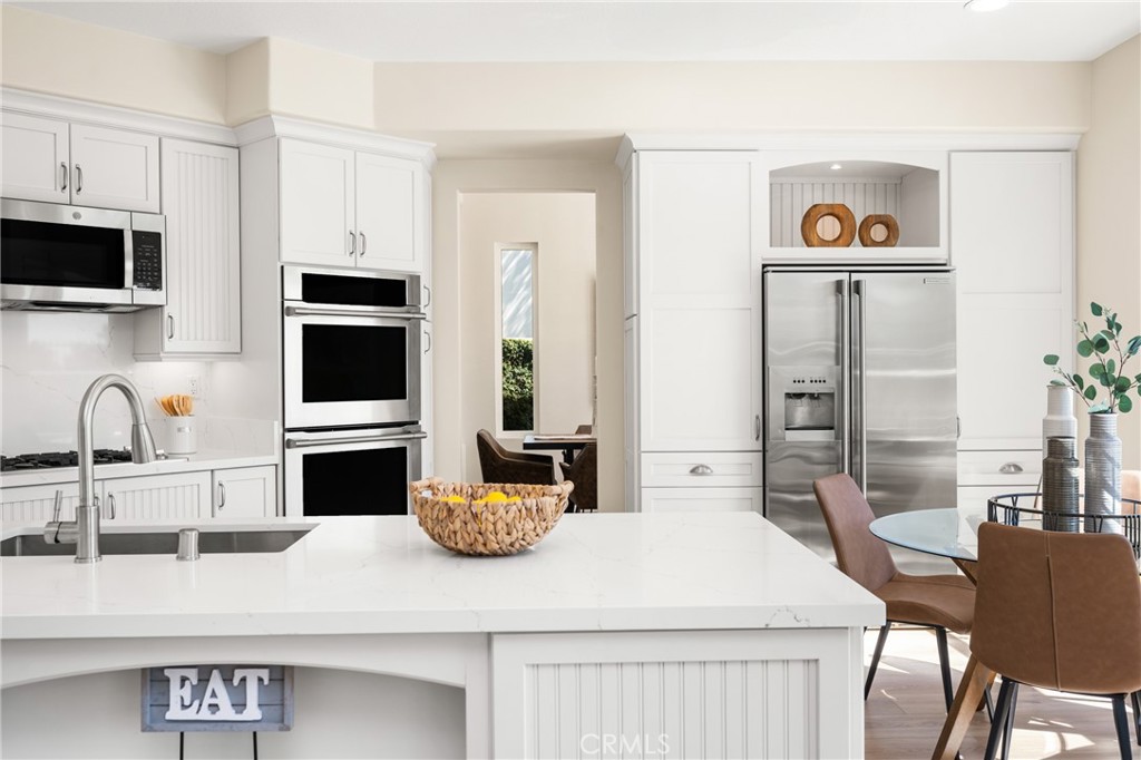 36 Mallorca Lake Forest, CA 92610 - Photo 27 of 64 a kitchen with stainless steel appliances kitchen island granite countertop a refrigerator a stove a sink and white cabinets